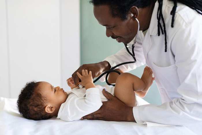 A doctor examining a baby with a stethoscope