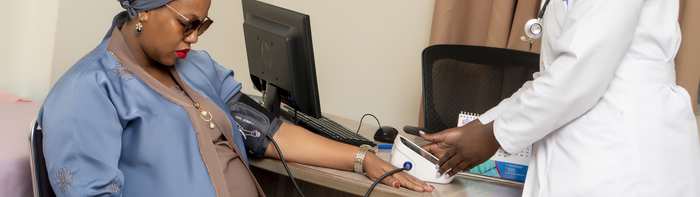 A clinician checking a patient's blood pressure during a consultation