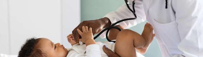 A doctor examining a baby with a stethoscope